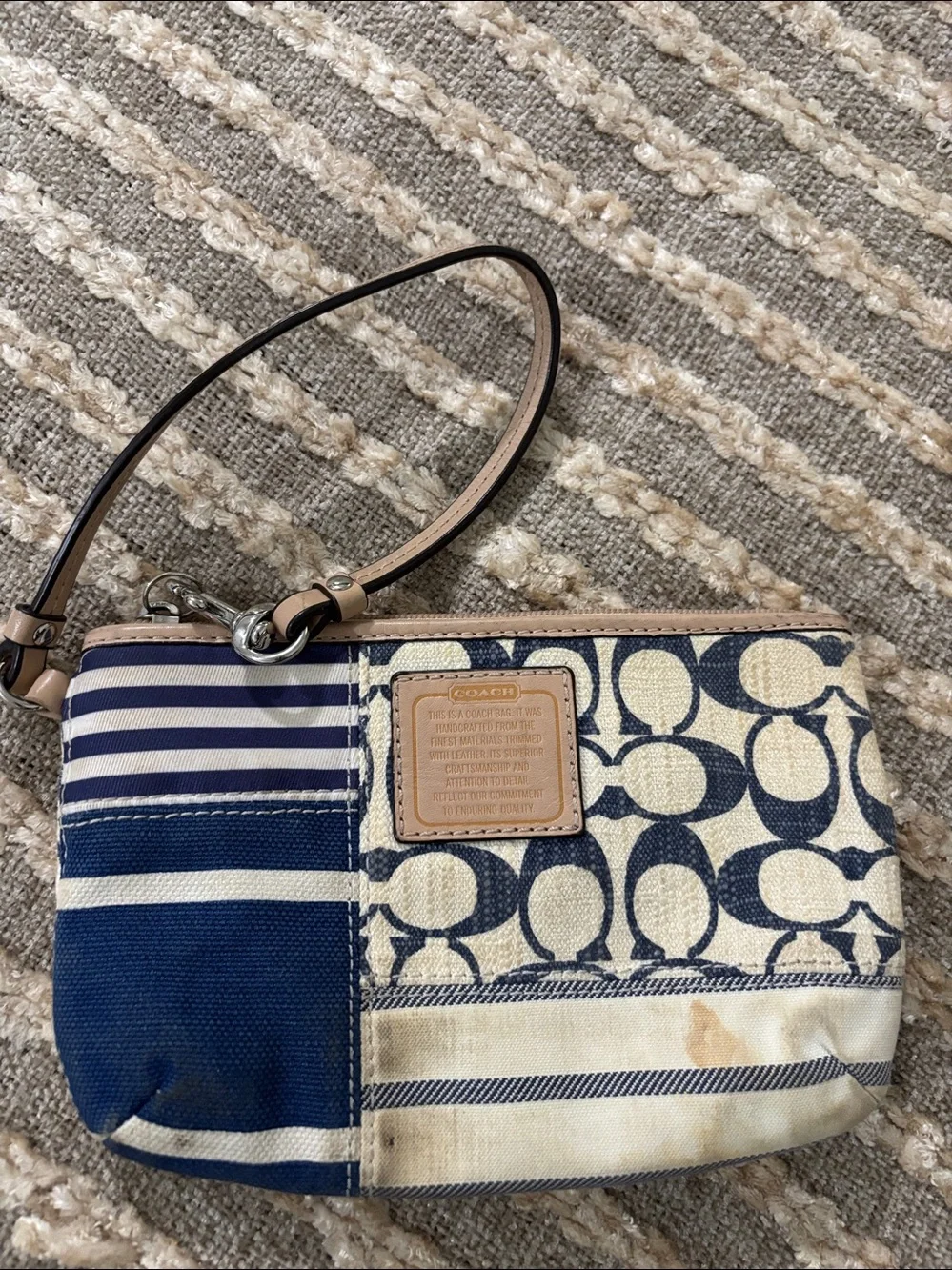 Coach wristlet featuring signature patchwork print in navy and cream